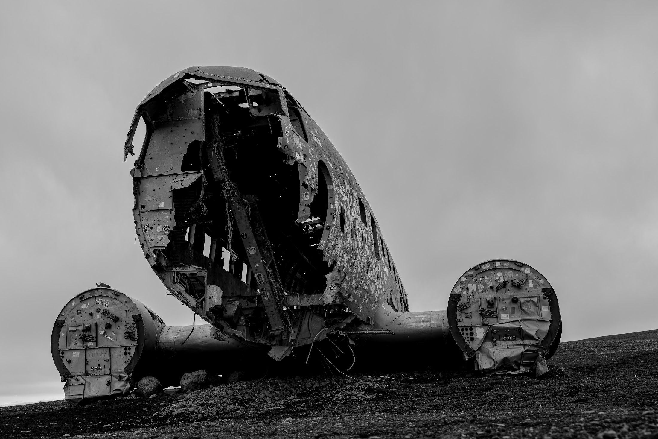 Flugzeugwrack einer DC-3 in Schwarzweiß auf der schwarzen Ebene von Sólheimasandur, Island